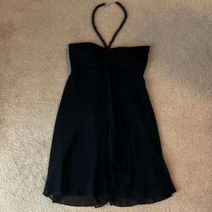 Like new black cocktail dress. Strapless with attached black bead halter strap.